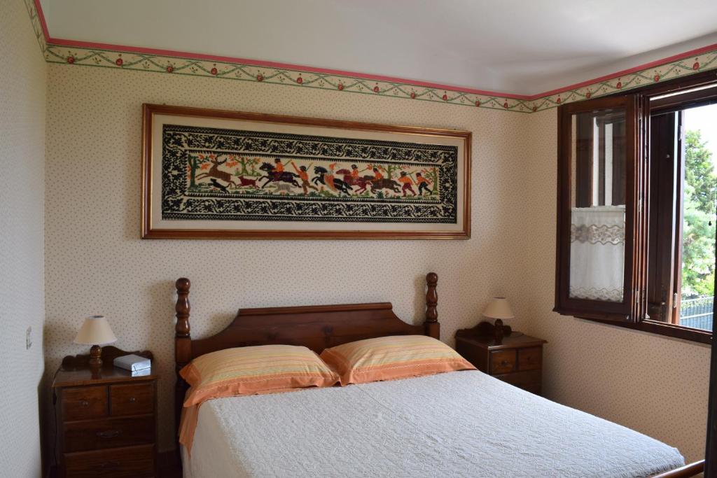 ein Schlafzimmer mit einem Bett und einem Wandgemälde in der Unterkunft Battistina Holiday Home in Monte Nai