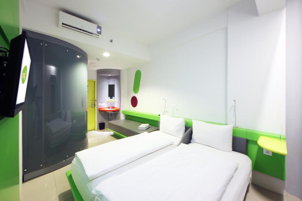 a bedroom with a white bed and a green wall at POP! Hotel Tebet Jakarta in Jakarta