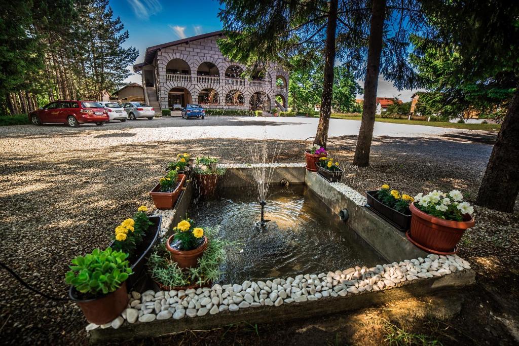 a fountain with flowers in pots in a parking lot at Vacation Home Keskic in Velika Gata