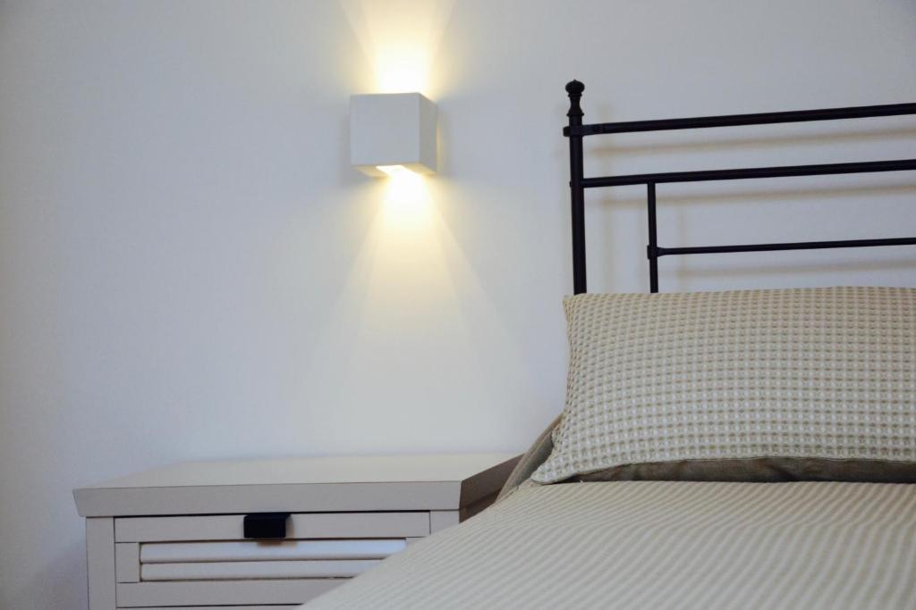 a bedroom with a bed and a nightstand with a lamp at Il Bottone al Duomo in Gaeta