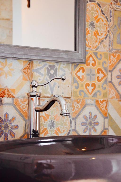 a bathroom sink with a faucet and a mirror at Il Bottone al Duomo in Gaeta