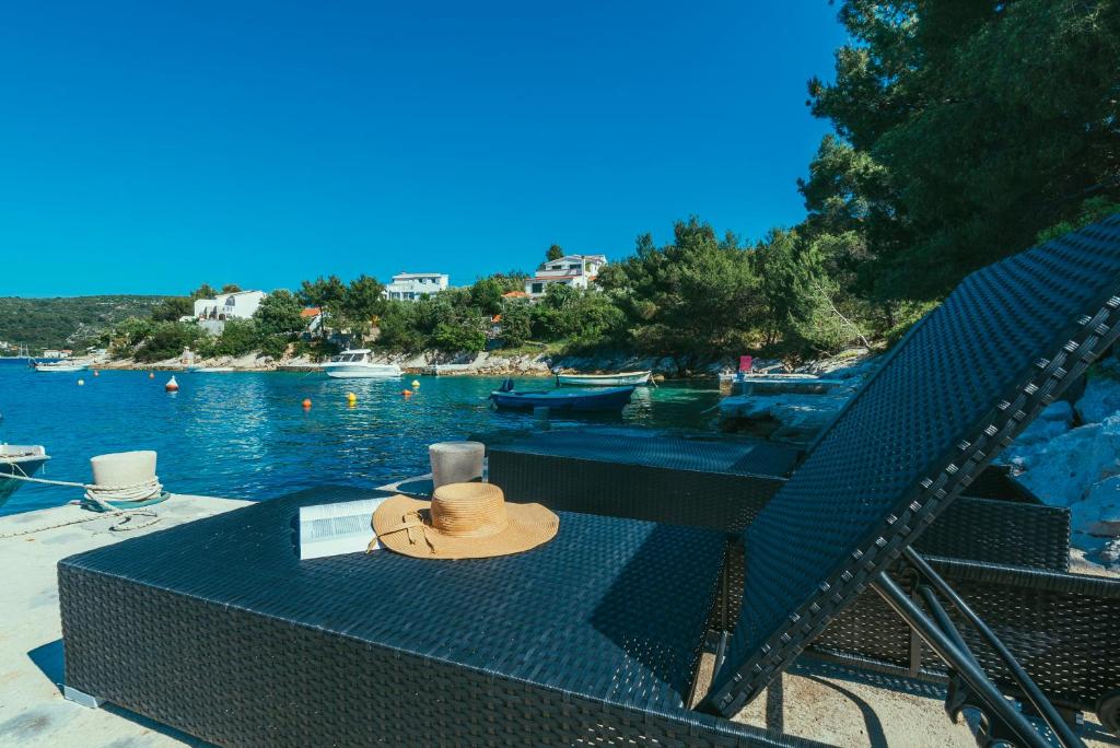 un sombrero sentado en una mesa junto al agua en Villa Relax, en Veliki Drvenik