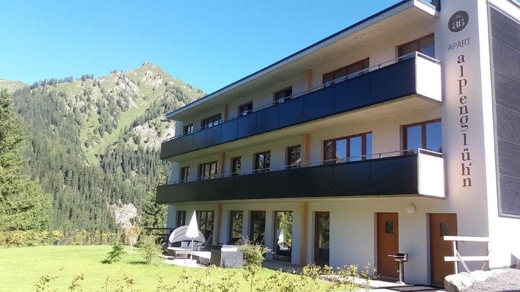 a building with a balcony with mountains in the background at Apart Alpenglüh´n in Spiss