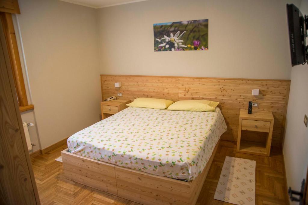 a small bedroom with a bed and two pillows at Albergo K2 in Madesimo