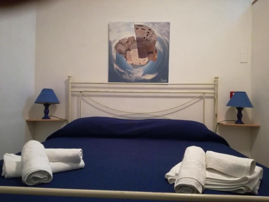 a bedroom with a blue bed with towels on it at Casa San Liberale in Trapani