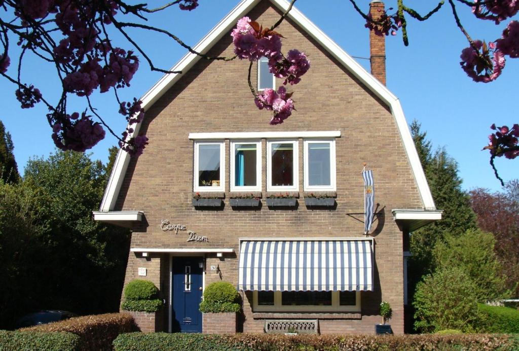 a house with purple flowers in front of it at B&B Carpe Diem in Hulst