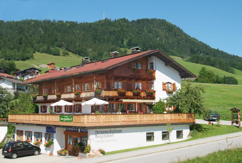 a large wooden building with a balcony on a hill at Gästehaus Bergstüberl in Reit im Winkl