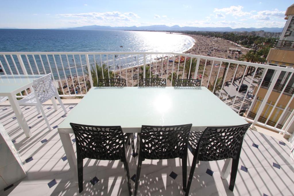 una mesa blanca y sillas en un balcón con vistas al océano en For a Stay Bello Horizonte, en Salou