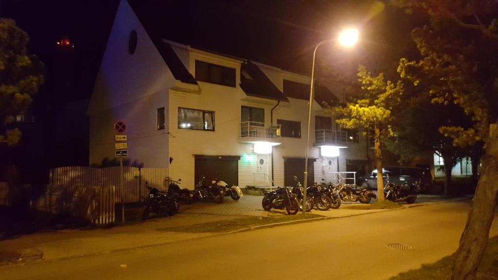 a group of motorcycles parked in front of a building at night at Muuli Ranna Hostel in Pärnu