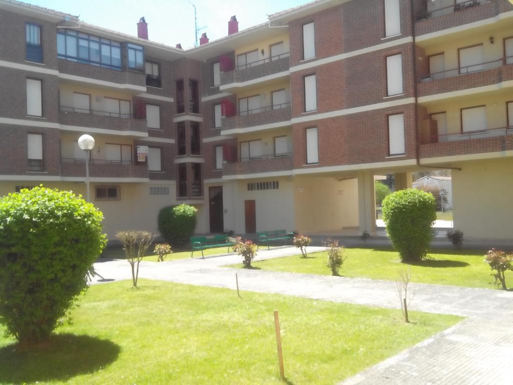 um edifício de apartamentos com um relvado em frente em Vivienda uso turistico con WiFi em Villarcayo de Merindad de Castilla la Vieja