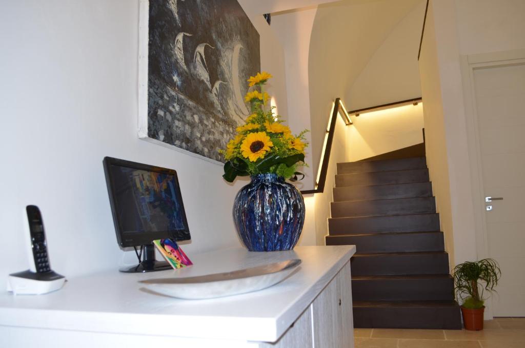 a blue vase with flowers on a counter with a staircase at B&B Salentus in Gallipoli