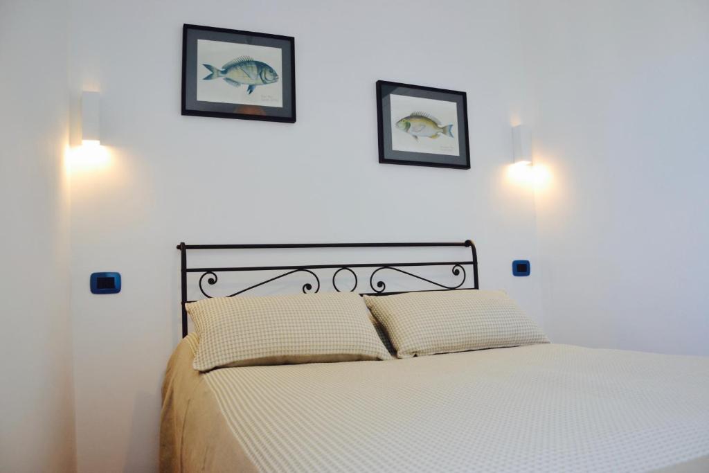 a bedroom with a bed with two pictures on the wall at Il Bottone al Duomo in Gaeta