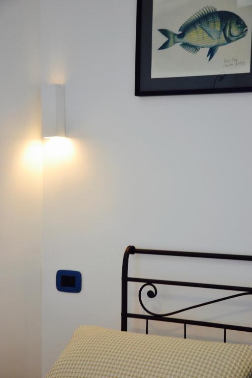 a bedroom with a bed with a picture of a fish on the wall at Il Bottone al Duomo in Gaeta