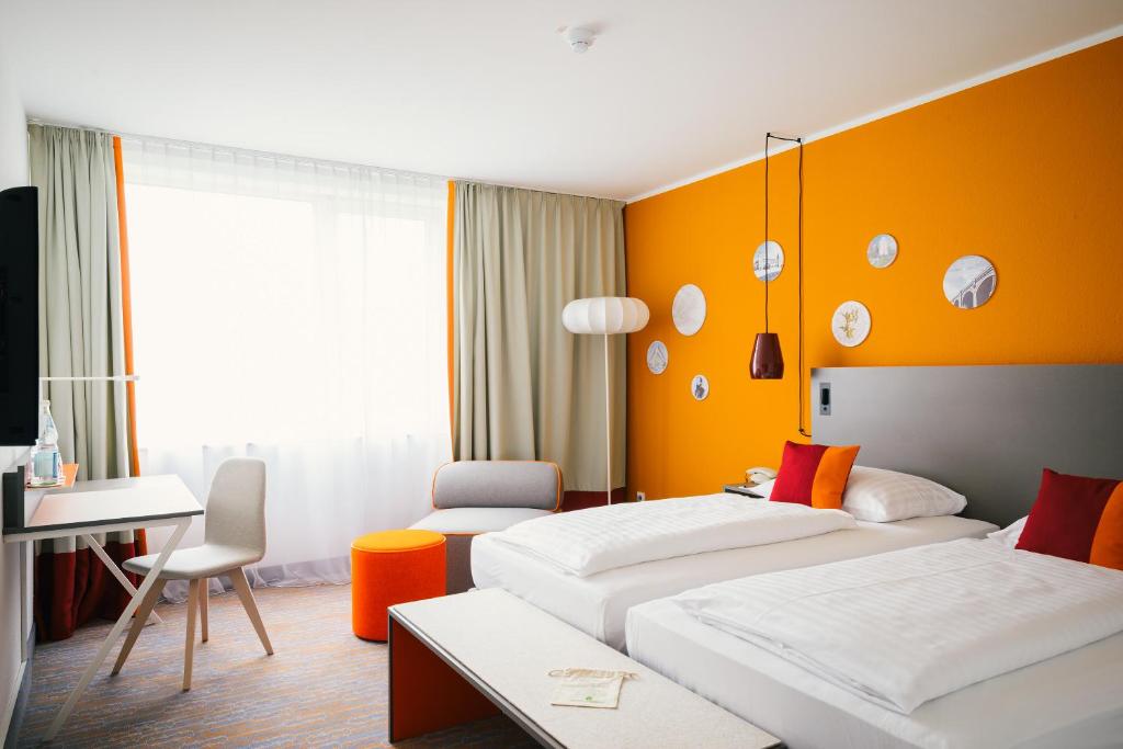 Een bed of bedden in een kamer bij Vienna House Easy Wuppertal
