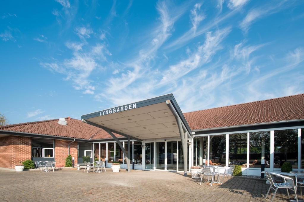 a building with tables and chairs in the courtyard at Hotel Lynggaarden in Herning