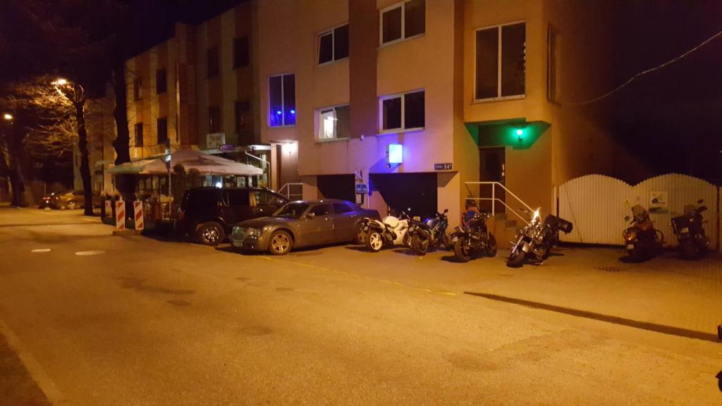 un coche aparcado en una calle por la noche con motocicletas en Ranna Sadama Villa, en Pärnu