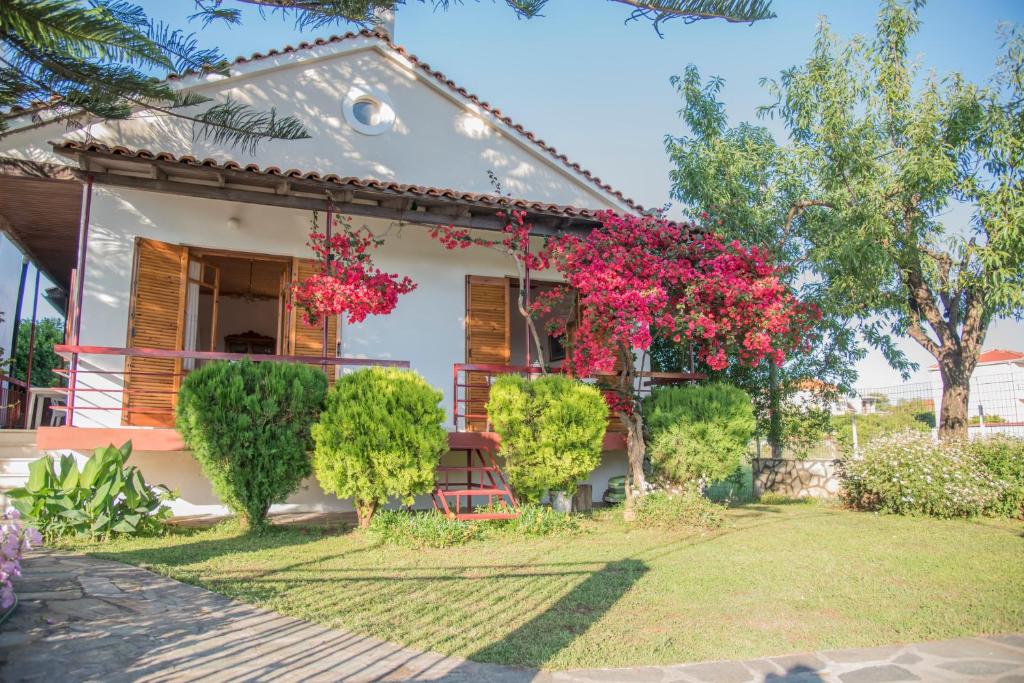 una casa con flores rosas en el patio en Demetra, en Mitikas