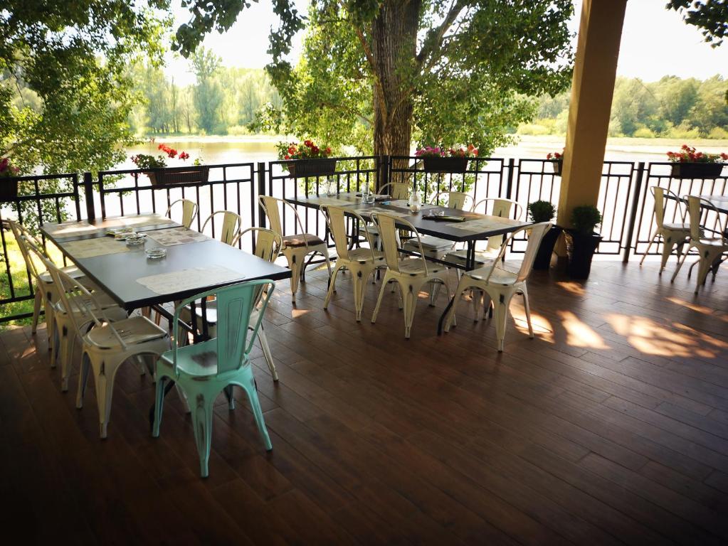 a group of tables and chairs on a deck at B&B Bela Vrba in Bačko Novo Selo