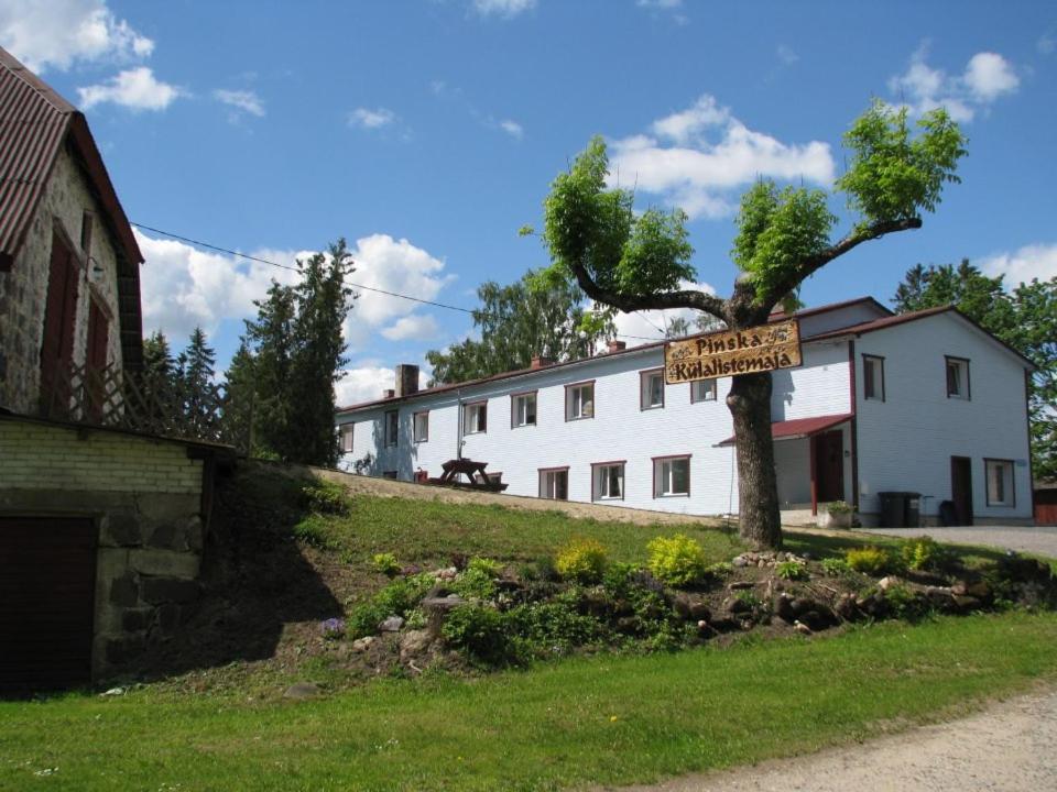 a sign on a tree in front of a building at Pinska Guesthouse in Pinska