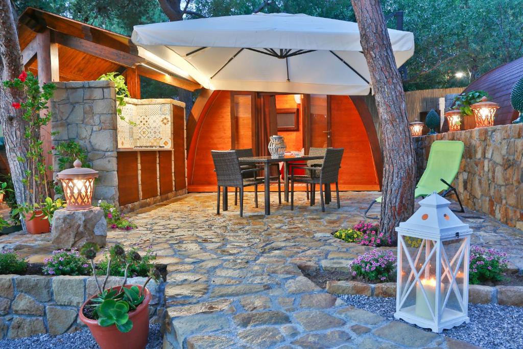 een patio met een parasol en een tafel en stoelen bij Campeggio Sanfilippo in Cefalù