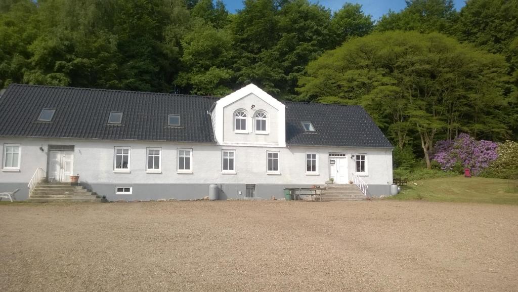 a large white house with a black roof at Moselundgaard B/B og Hestehotel in Engesvang