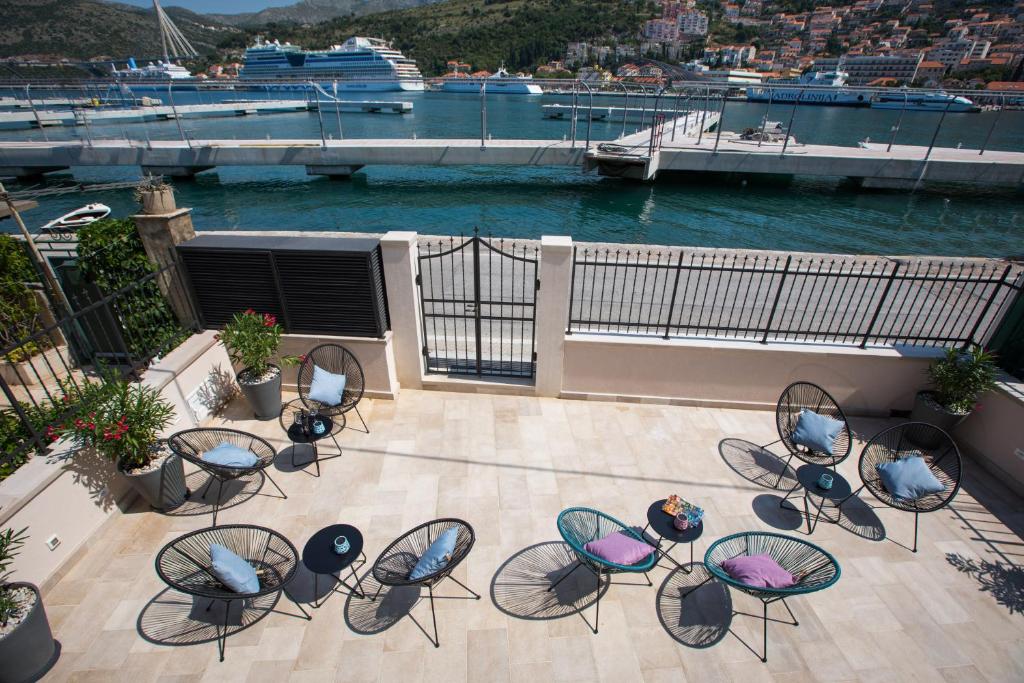 an outdoor patio with chairs and tables and a marina at Bova Luxury Rooms in Dubrovnik