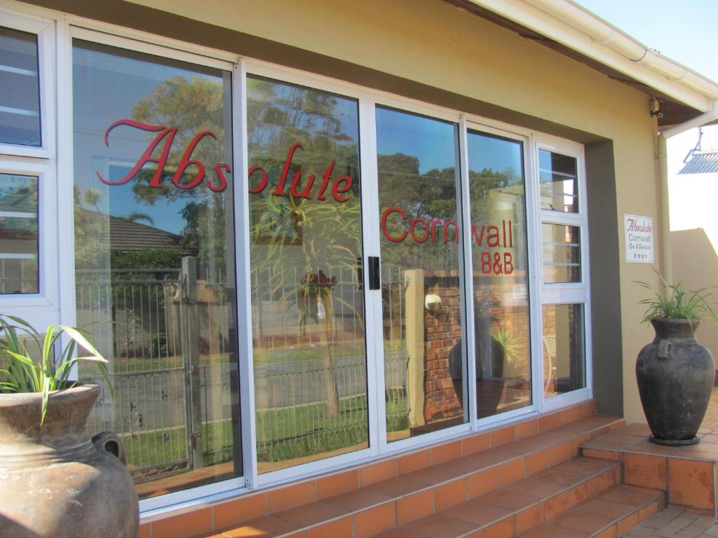 a store front window with aolis white sign on it at Absolute Cornwall Bed and Breakfast in East London