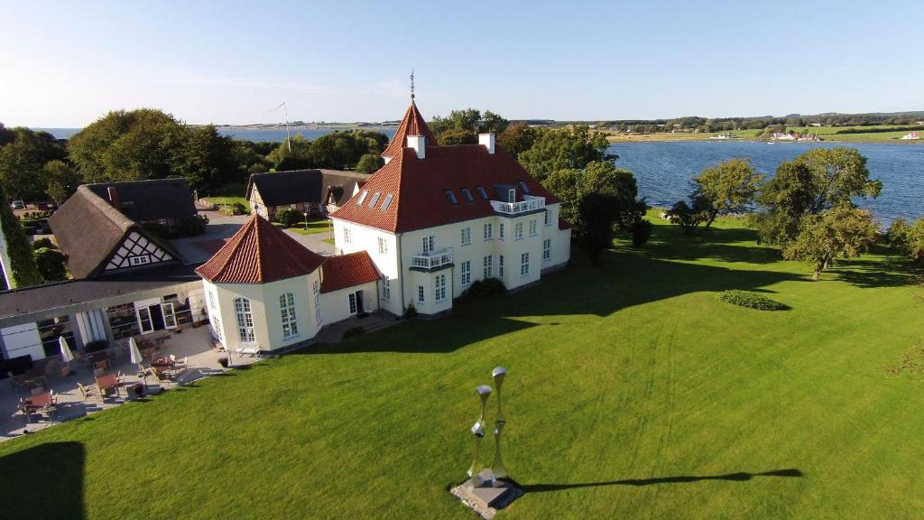 an aerial view of a large white house on a grass field at Gl. Avernæs Sinatur Hotel & Konference in Ebberup