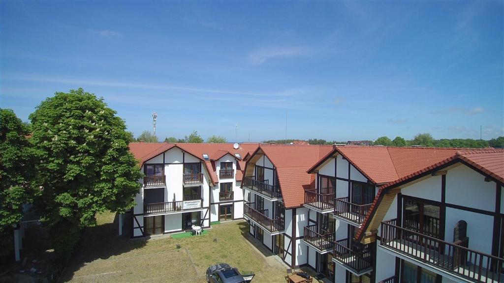 una fila de edificios de apartamentos con techos rojos en Apartament Nad Morzem en Rowy