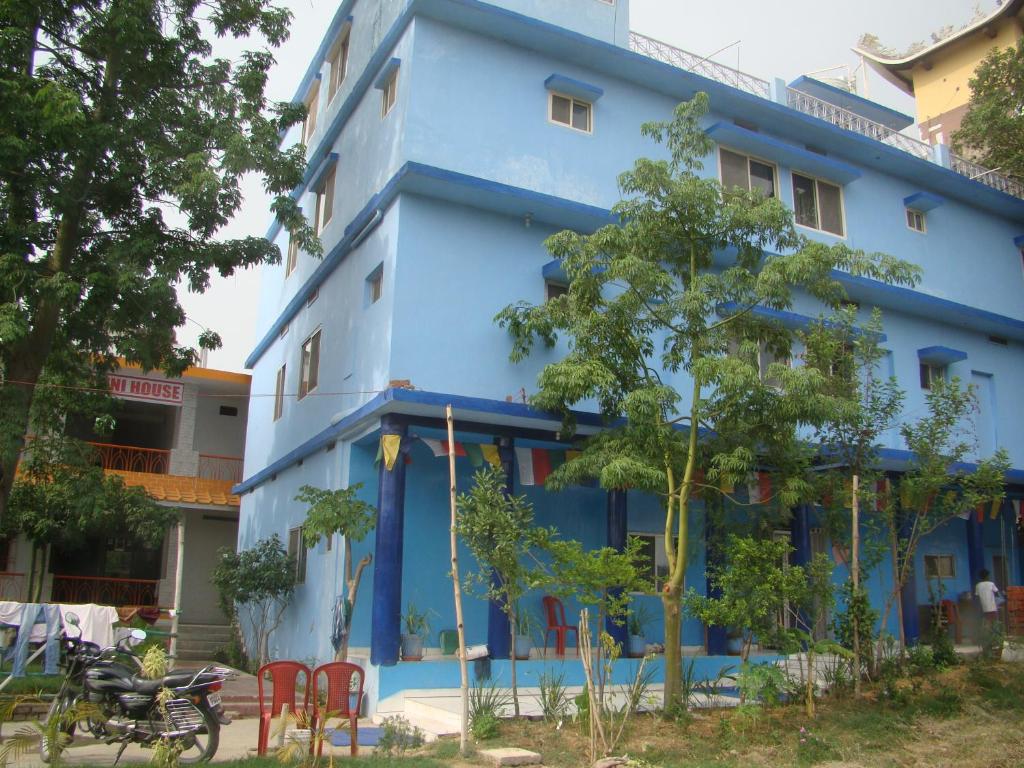 a blue building with red chairs in front of it at Tara Guest House in Bodh Gaya