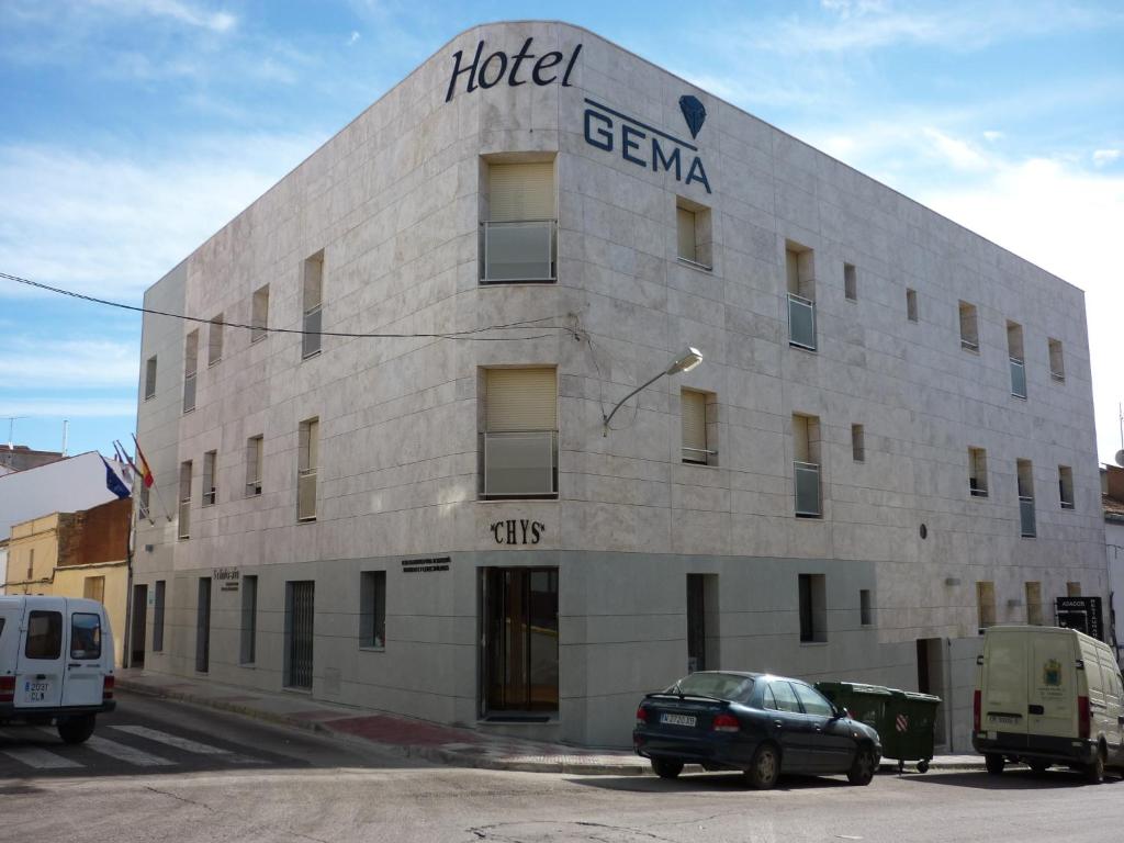 ein Hotelgebäude mit einem davor geparkt in der Unterkunft Hotel Gema in Almadén