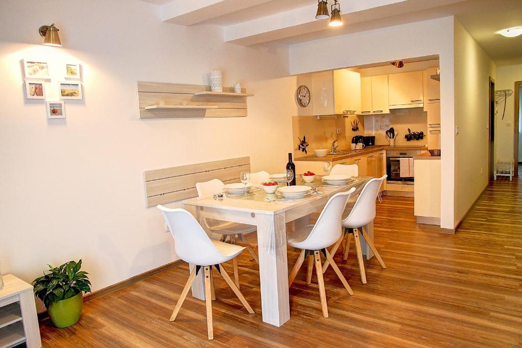 een keuken en eetkamer met een witte tafel en stoelen bij Apartment Vita near Terme Paradiso in Dobova