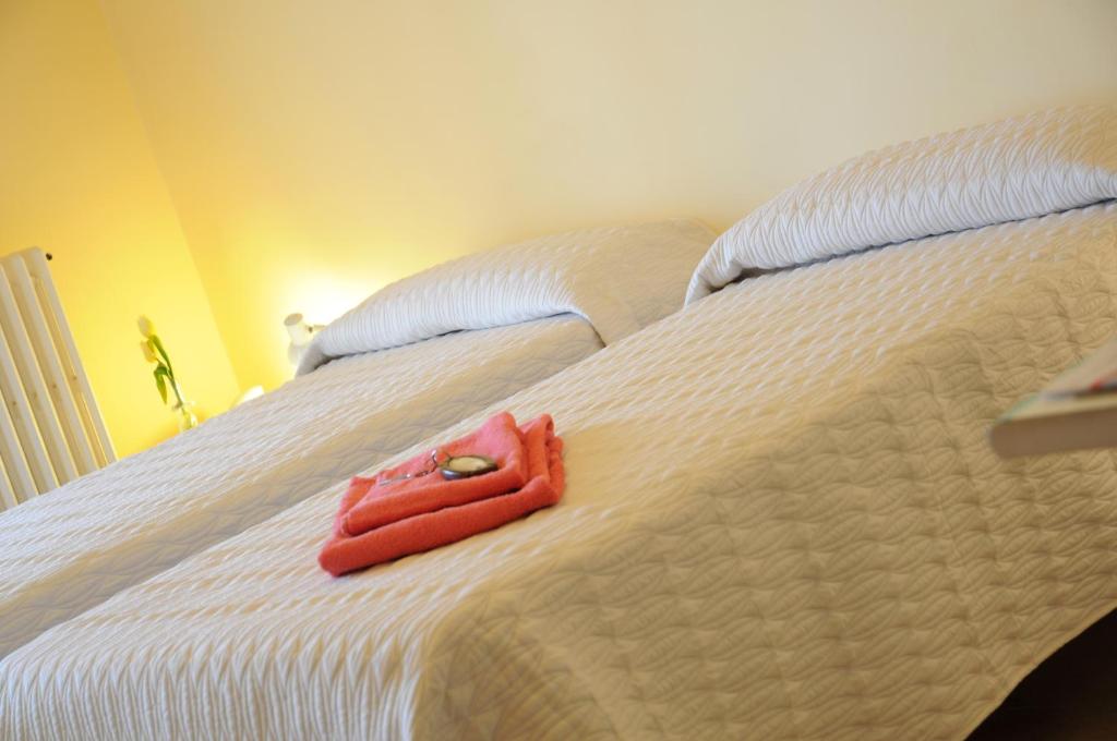 キアラモンテ・グルフィにあるAlbergo Villa Nobileの白いベッドに座る赤いタオル