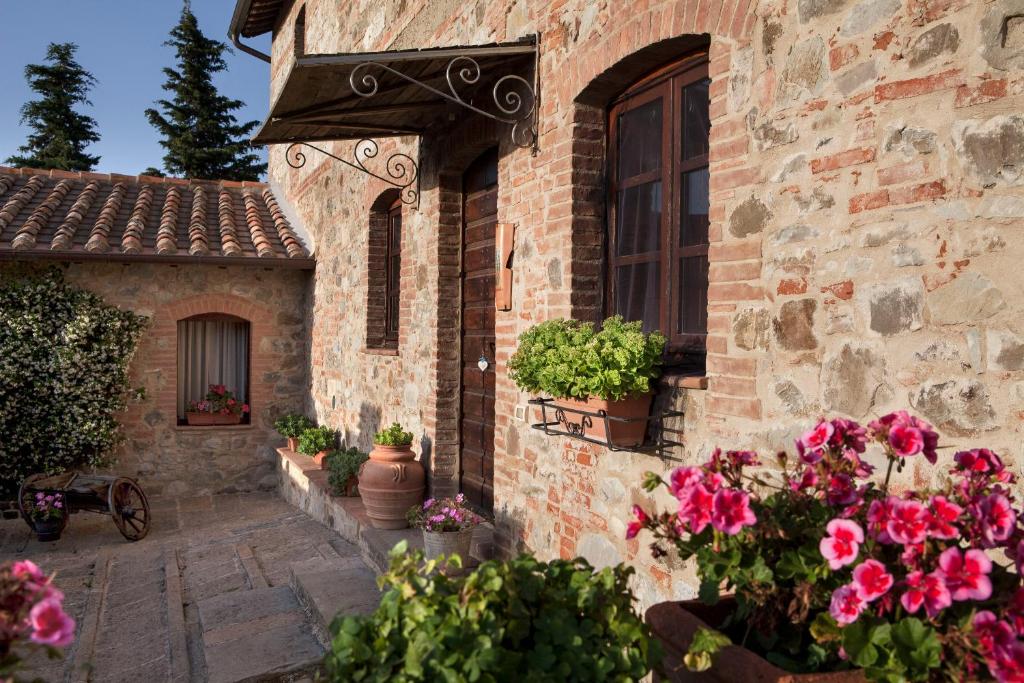 un edificio de ladrillo con flores a un lado. en Agriturismo La Provenca, en Chianciano Terme