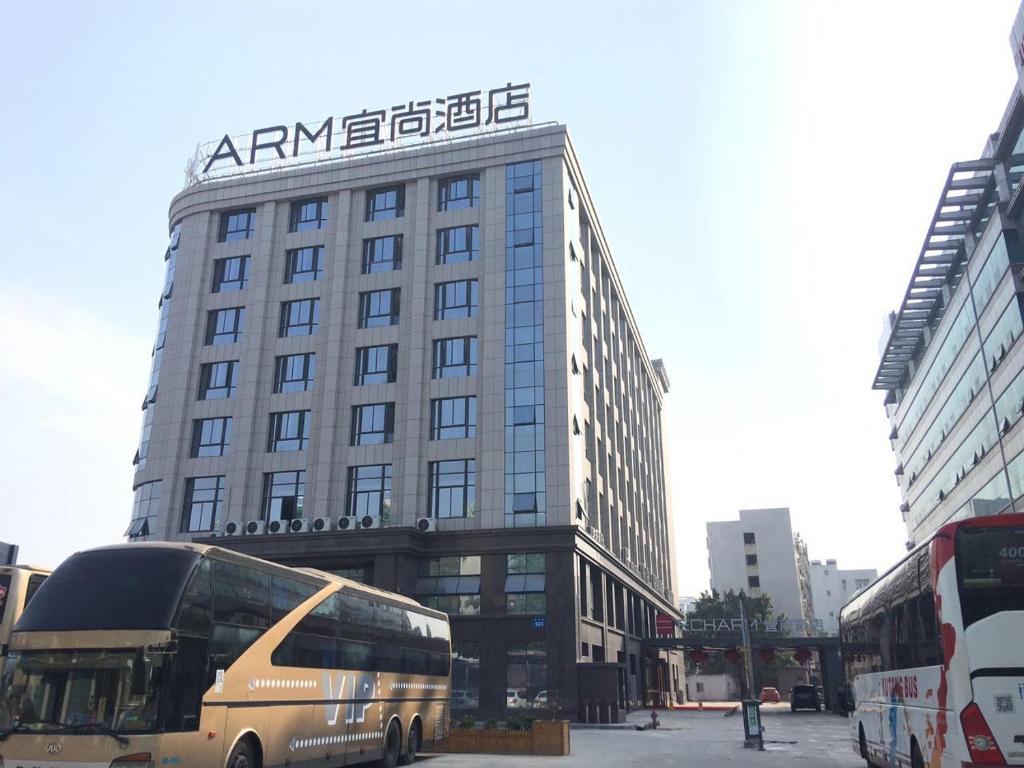 a bus is parked in front of a building at Echarm Hotel Xiamen Airport Hi-tech Park in Xiamen