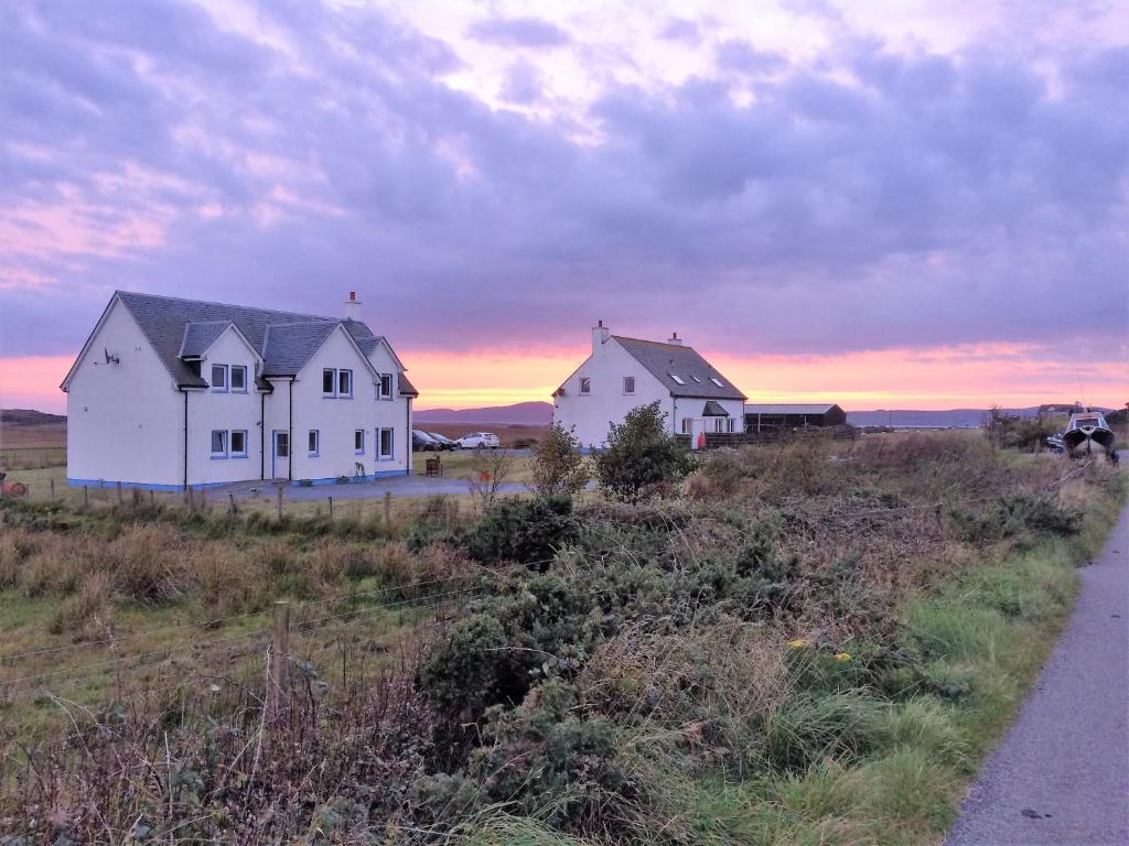 two white houses in a field at sunset at Dha Urlar in Bowmore