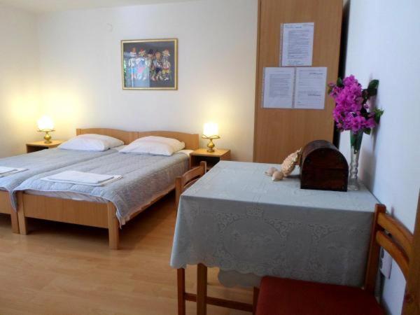 ein Schlafzimmer mit 2 Betten und einem Tisch mit Blumen in der Unterkunft Nice Studio apartment for 2 in Dubrovnik