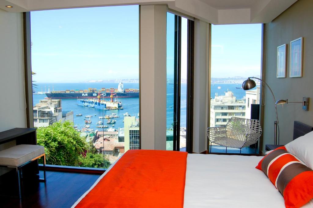 a bedroom with a large view of a harbor at Hotel Boutique 17 in Valparaíso