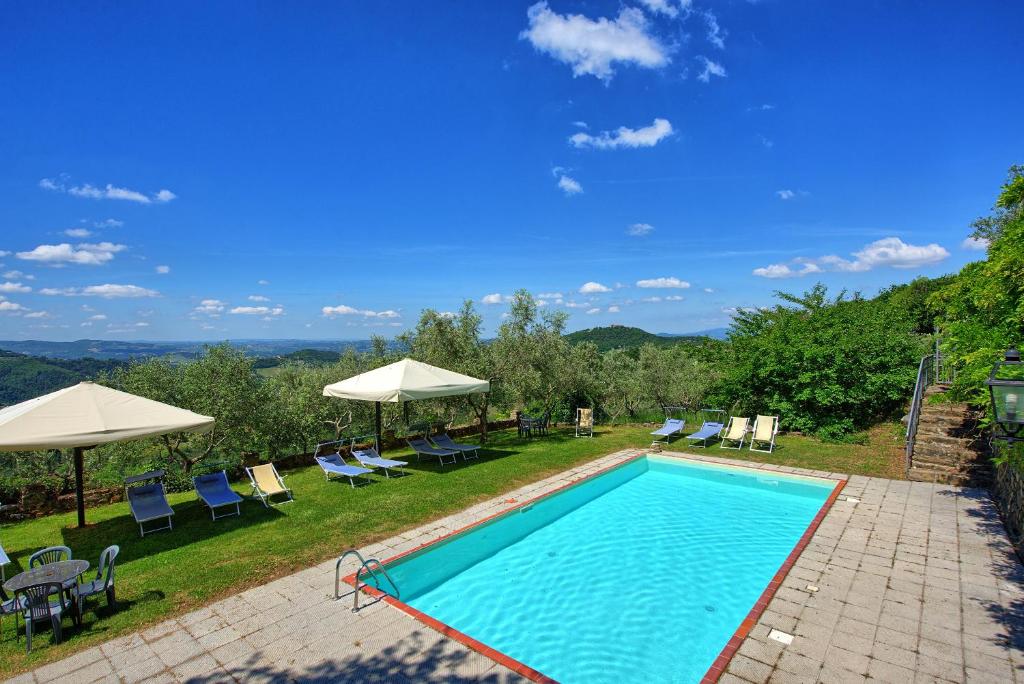 una piscina con sillas y sombrillas en Villa Panzalla by PosarelliVillas, en Santo Stefano A Tizzano