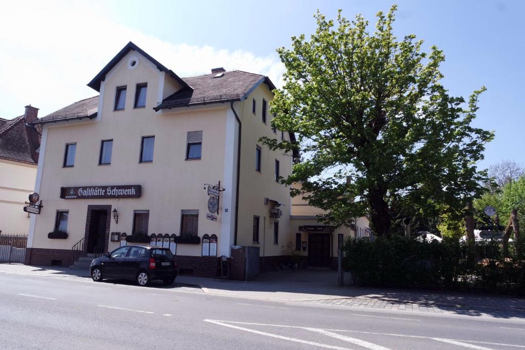 um carro estacionado em frente a um edifício branco em Gaststätte Schwenksaal em Bayreuth