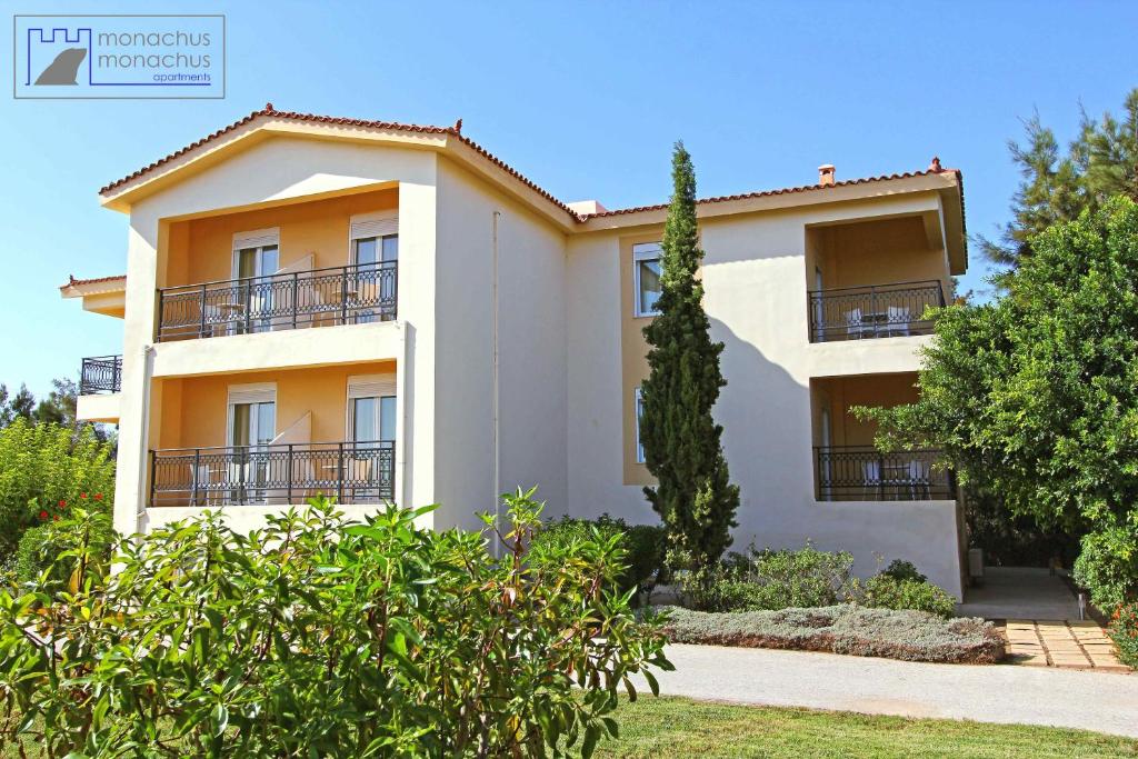 a building with balconies and trees in front of it at Monachus Monachus in Frangokastello