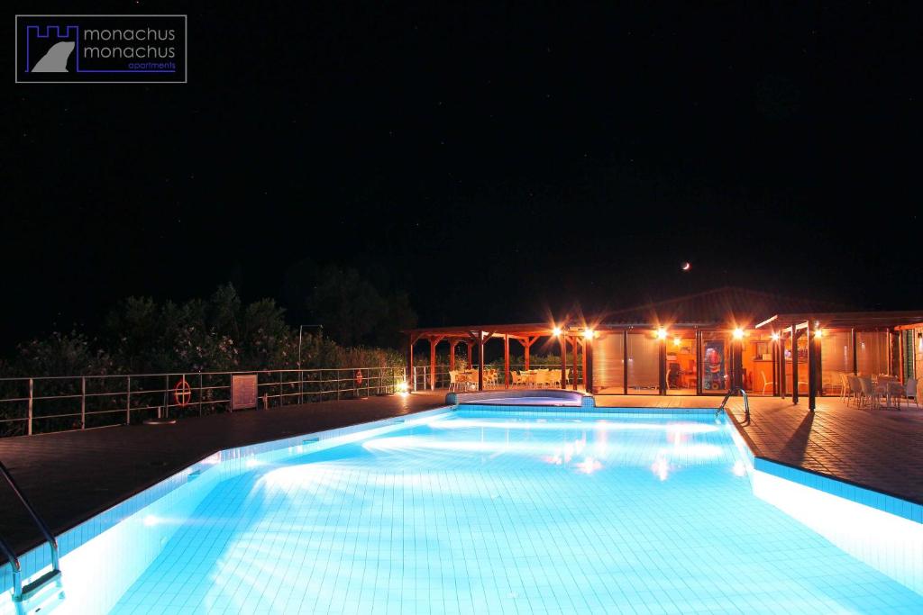 a large swimming pool at night with lights on it at Monachus Monachus in Frangokastello