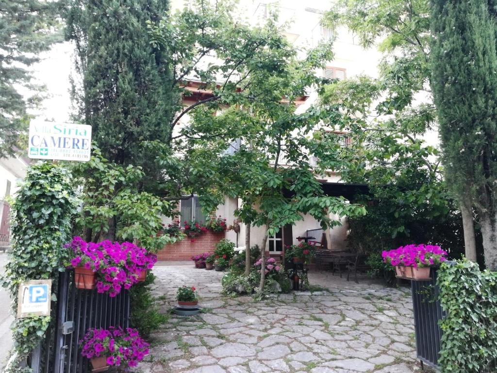 un jardin avec des fleurs en pots sur une clôture dans l'établissement B&B Leggieri Villa Siria, à San Giovanni Rotondo