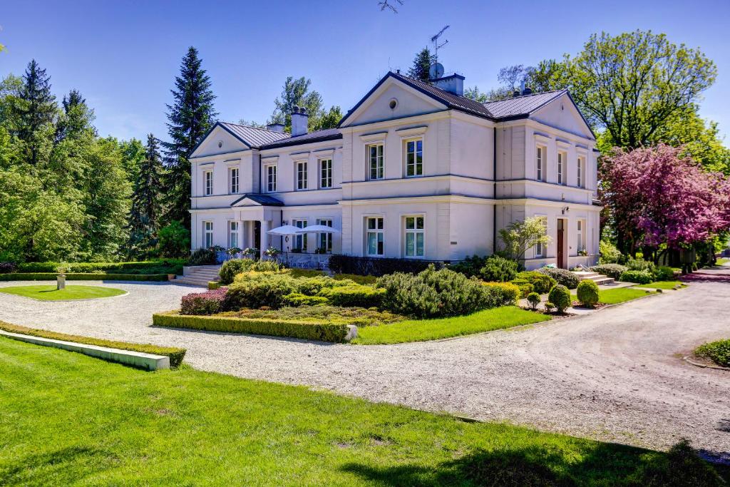 a large white house with a driveway at Biały Pałac Palczew in Palczew