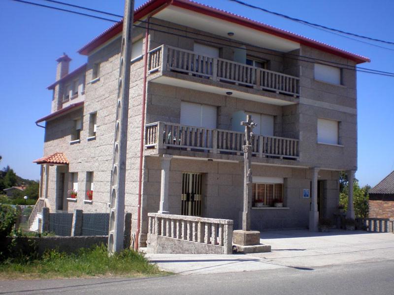 a large brick building with a balcony on it at A Casa De Amparo in Sanxenxo