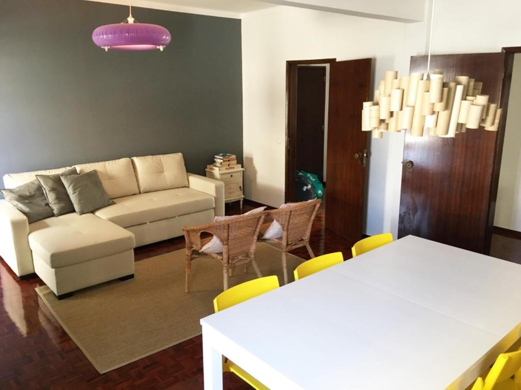 een woonkamer met een bank en een tafel en stoelen bij Lemon Tree Apartments in Faro