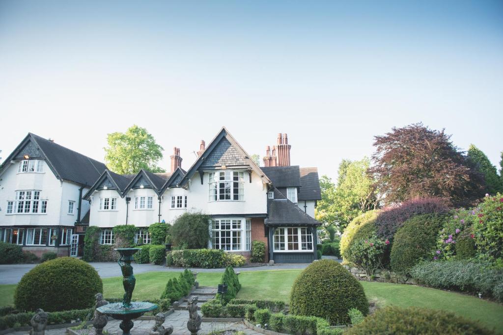 a house with a garden in front of it at Mere Court Hotel in Knutsford