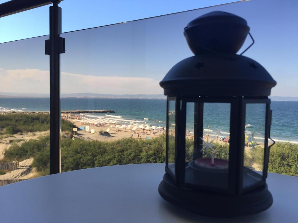 una linterna sobre una mesa con vistas a la playa en Elizabeth' Luxury Apartments en Pomorie