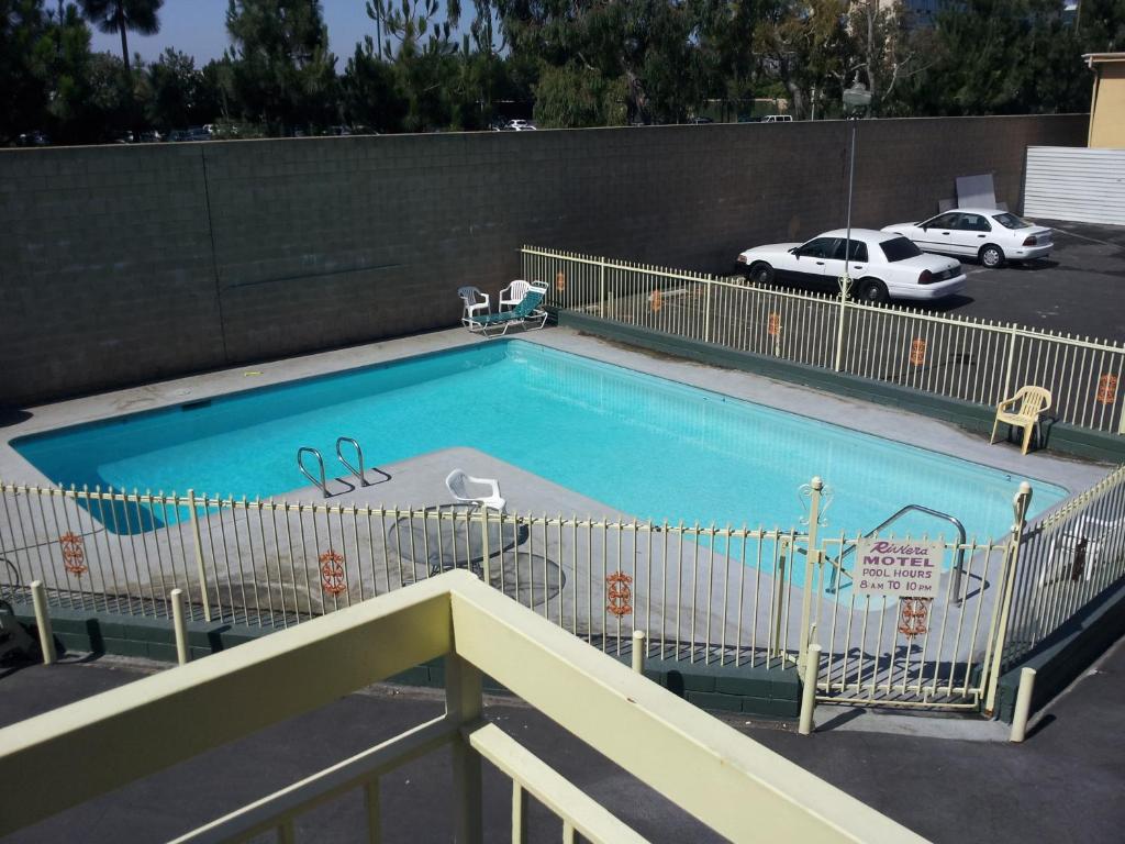 a large swimming pool in a parking lot at Riviera Motel in Anaheim