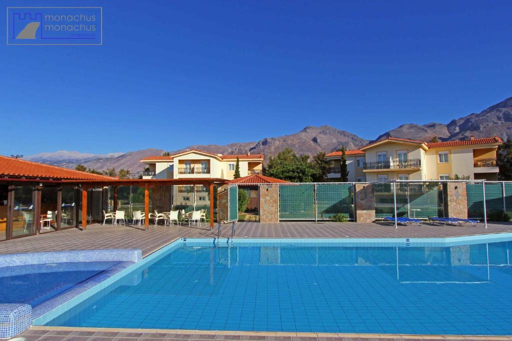 a swimming pool in front of some houses at Monachus Monachus in Frangokastello